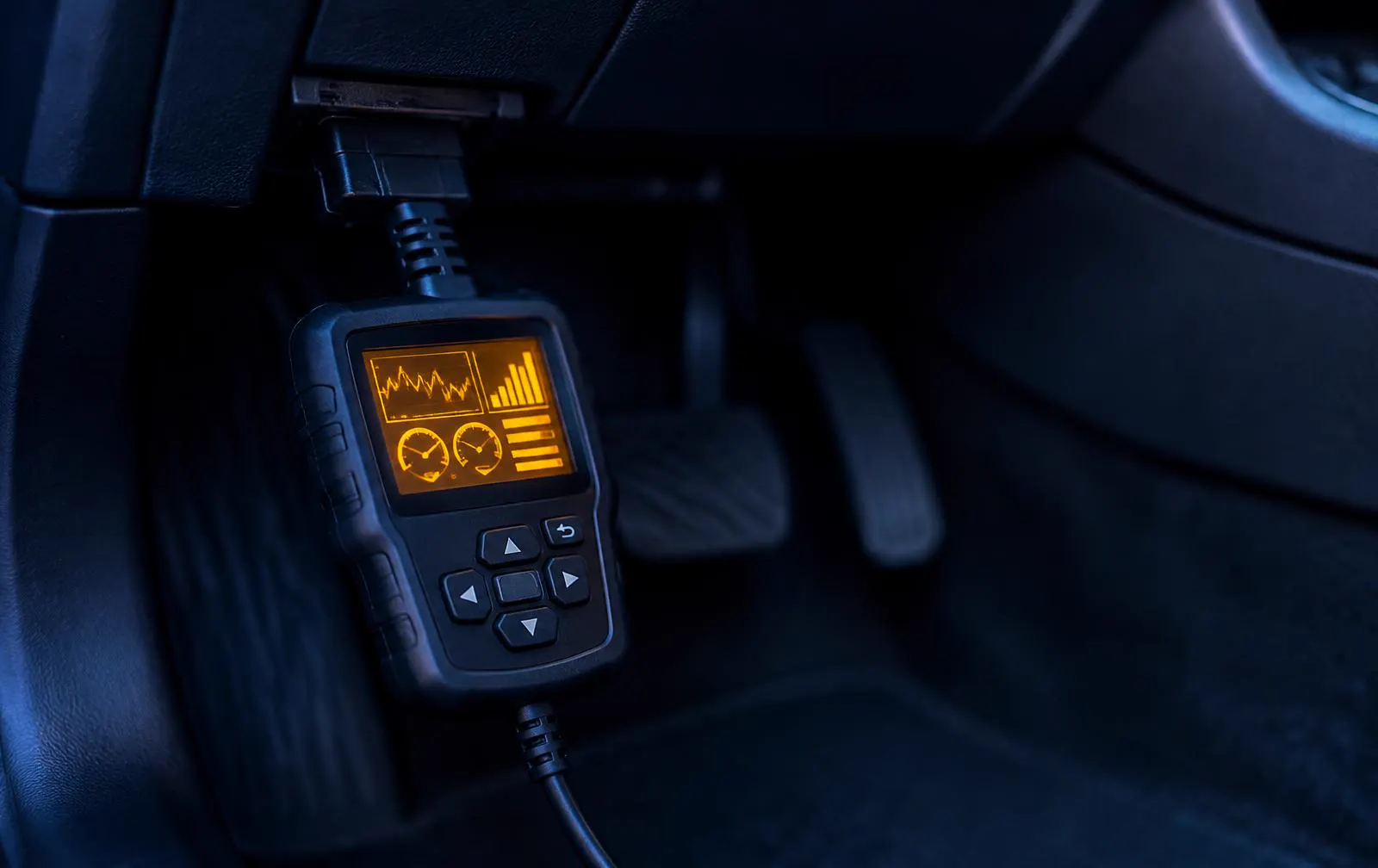 Diagnostic scan tool connected under a car dashboard